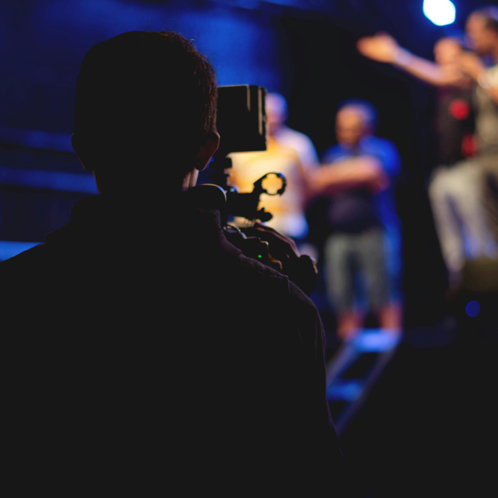 Man Standing on Stage Holding Microphone